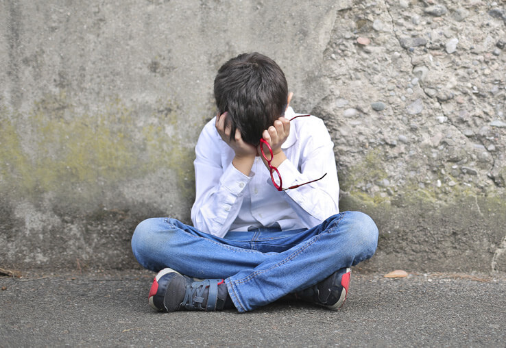 Unhappy child sitting - effects of parental substance abuse
